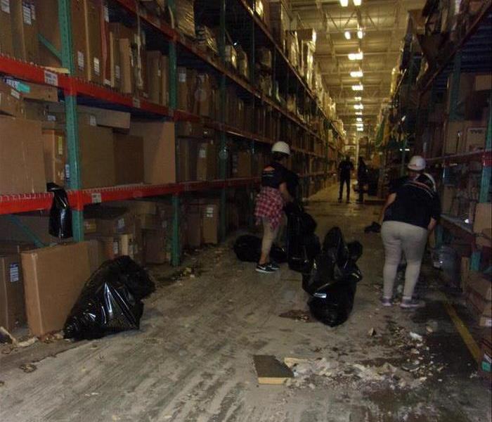 Team members in action cleaning in warehouse.