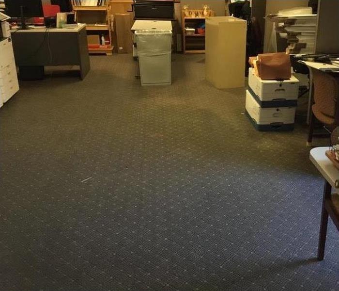 Wet carpet in office building, file cabinets, boxes, desk